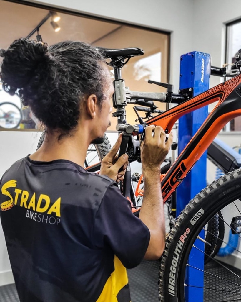 Mecânico da Strada ajustando uma bicicleta